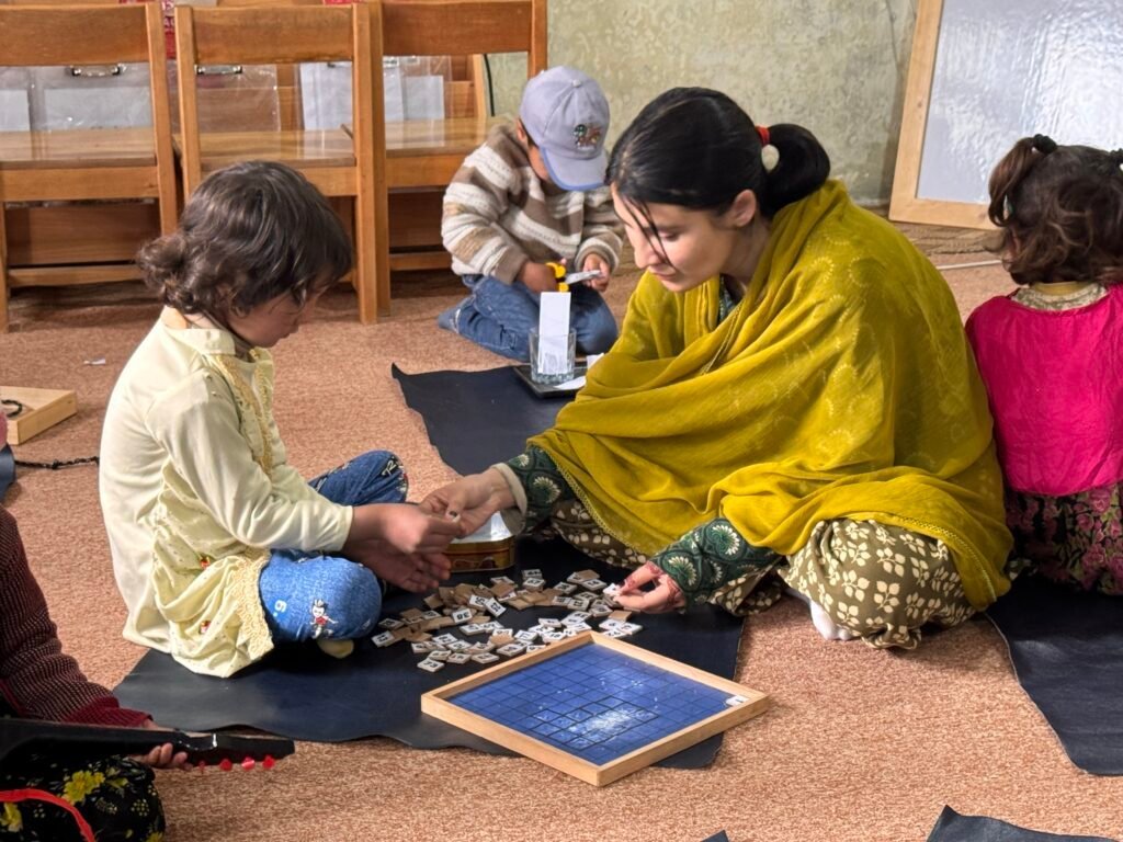 A Montessori-trained teacher guiding young learners in Chitral.