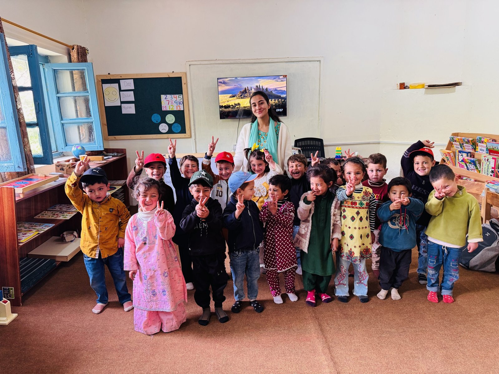 A full classroom celebrates together for a group photo with their teacher.